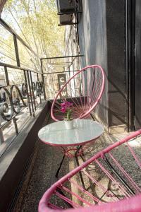 布宜诺斯艾利斯PH Palermo Hostel的阳台的粉红色椅子和桌子