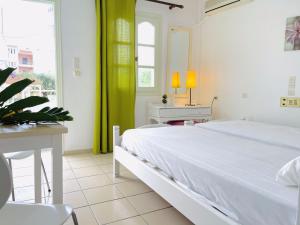 赫索尼索斯Optasia Apartments的卧室配有白色的床、桌子和窗户。