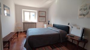 里米尼Al Ponte di Tiberio的一间卧室配有一张床、一张桌子和一个窗户。