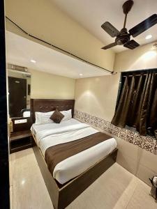孟买KALPANA RESIDENCY - Near US Embassy的一间卧室配有一张床和吊扇