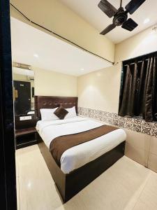 孟买KALPANA RESIDENCY - Near US Embassy的一间卧室配有一张大床和吊扇
