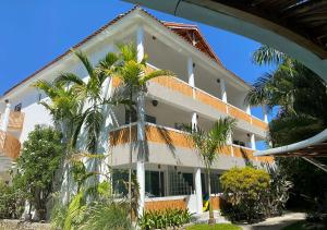 喀巴里特卡巴雷巴伊亚公寓式酒店的一座白色的大建筑,前面有棕榈树