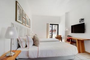 卡武埃鲁Hotel Carvoeiro Plaza的一间白色卧室,配有床和电视