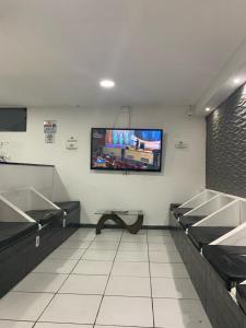 圣保罗Estação Hostel - Em frente ao Metrô的一间墙上配有平面电视的等候室