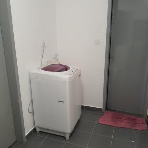 Bandar Puncak AlamD Laman Haris Homestay的带淋浴的浴室内的白色洗衣机和烘干机