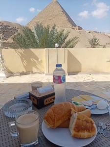 开罗Mamado PYRAMIDS VIEW的一张桌子,上面放着一盘面包和一瓶水