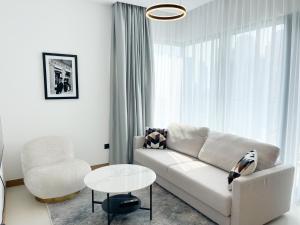 迪拜Luxury living at Vida Marina & Yacht Club的客厅配有沙发、椅子和桌子