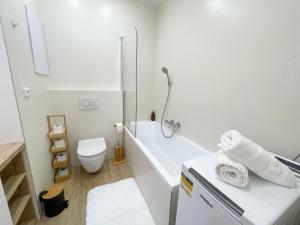 科希策Luxury City Retreat with Terrace的白色的浴室设有浴缸和卫生间。