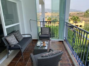 卡拉德米哈斯Apartment Summer Vibes Miraflores - La Cala de Mijas的阳台配有椅子和茶几。