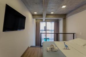 波哥大Cosmos Suites Chapinero Alto的一间卧室配有一张床和一台平面电视