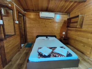 巴加Pousada Donaciana - Beach Cottages的木制客房内的一间卧室,配有一张床