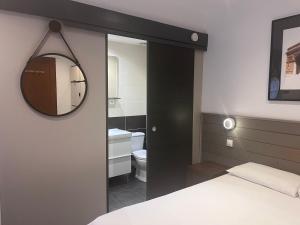 维勒瑞夫自由别墅酒店的一间卧室,配有带镜子的浴室和一张床