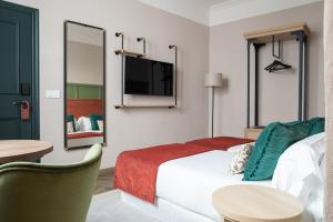 塞维利亚The Honest Hotel & Apartments的一间酒店客房,配有一张床和一台电视