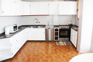 阿利坎特Apartamento Torre Alacant的厨房配有白色橱柜、水槽和微波炉