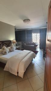比勒陀利亚奥皮库皮宾馆的一间卧室配有一张大床和一张沙发