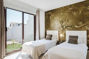 普拉亚布兰卡Villa Faro的酒店客房设有两张床和窗户。