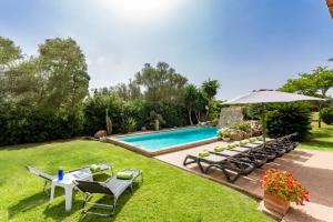 BiniparrellVilla Son Tretze by Villa Plus的后院设有游泳池、桌椅和遮阳伞