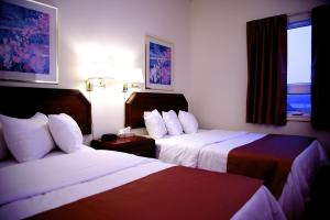 钱纳尔-巴斯克港巴斯克港口酒店的酒店客房设有两张床和窗户。