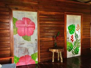 巴斯蒂门多斯True Nature Jungle House的一间房间,两扇门上涂有鲜花