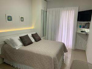 弗洛里亚诺波利斯克里斯塔尔旅馆的一间卧室配有带两个枕头的床和窗户