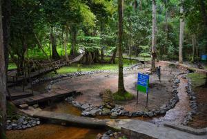 IkogosiIKOGOSI WARM SPRINGS RESORT的公园,有一条河,有岩石和标志