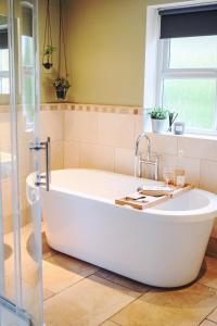 约克Little Lodge on the Yorkshire Wolds的带窗户的浴室内的白色浴缸