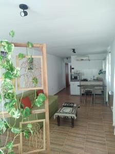 科尔多瓦Makipura的一间带绿色沙发的客厅和一间厨房