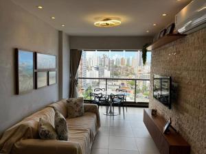 萨尔瓦多Salvador farol da barra 01 Apartamento Vista Mar的带沙发的客厅,享有城市美景