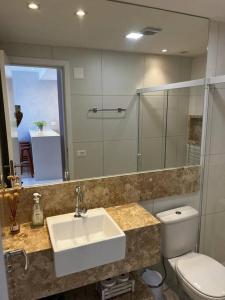萨尔瓦多Salvador farol da barra 01 Apartamento Vista Mar的一间带水槽、卫生间和镜子的浴室