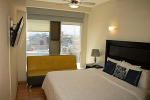 墨西哥城Puerta Alameda Suites México的一间卧室设有一张大床和一个窗户。