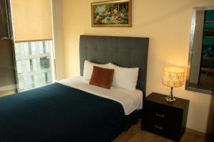 墨西哥城Puerta Alameda Suites México的一间卧室配有一张大床和一盏灯