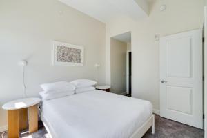 费城Mint House at The Divine Lorraine Hotel - Philadelphia的白色的卧室设有白色的床和门