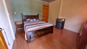 德雷克Hotel Gitana Corcovado, y Tour operador的一间卧室配有一张床和一个小冰箱
