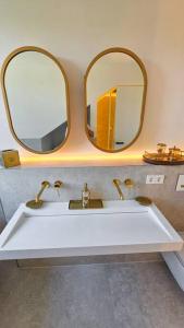 慕尼黑Neubau stilvolle Dachgeschoss City Wohnung的浴室设有两面镜子和白色水槽