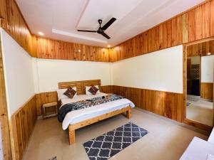 卡索尔The Stream Kasol的卧室配有一张床铺,位于带木墙的房间内