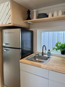佩里The Mockingbird Tiny Home的厨房配有冰箱和水槽