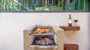 福尔图纳Cerro Chato's House的烧烤架,包括一瓶葡萄酒和一杯
