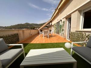 ValliranaCasa con piscina y vistas en Vallirana/Barcelona的阳台的天井配有桌椅