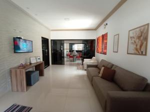马拉戈日Casa MARAGOGI com PISCINA e área GOURMET COMPLETA的客厅配有沙发和墙上的电视