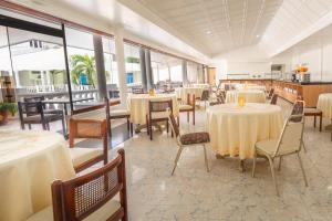 圣安德烈斯Hotel Americas San Andres Islas Colombia的用餐室设有桌椅和窗户。