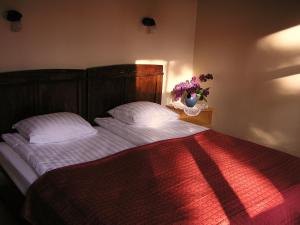 尤尔马拉玛尧鲁海滨大道宾馆的一间卧室配有一张带白色床单和花瓶的床。