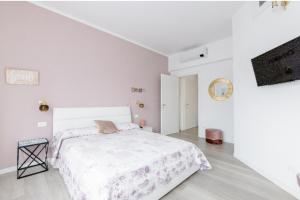 菲纳莱利古雷Casa di Kiki的一间白色卧室,配有床和电视