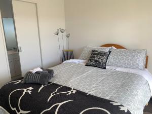 蒂阿瑙A Beauty on Bligh St Te Anau的一间卧室配有一张带黑白色棉被的床