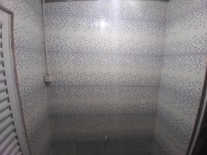 弗洛里亚诺波利斯Pousada & Hostel Mar dos Ingleses的浴室铺有黑白瓷砖,设有淋浴。