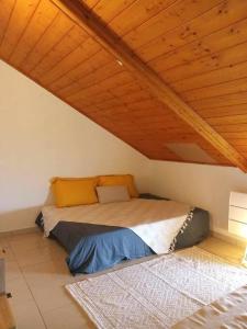 圣若瑟LE GRAND COUDE的木天花板的客房内的一张床位