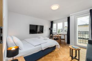 华沙Apartament Jasna by Your Freedom的一间卧室配有一张带电视和桌子的床。