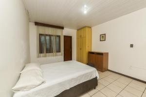 弗洛里亚诺波利斯Rental Florianópolis - Acomodações Residenciais的卧室配有白色的床和窗户。