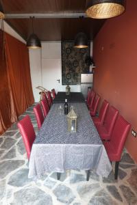 CampinhoAladin Comfort Country House的一间带桌子和红色椅子的用餐室