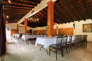 乌鲁阿潘Hotel Pie de la Sierra的宴会厅配有白色的桌椅