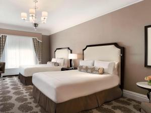 旧金山旧金山费尔蒙特酒店的酒店客房设有两张床和吊灯。